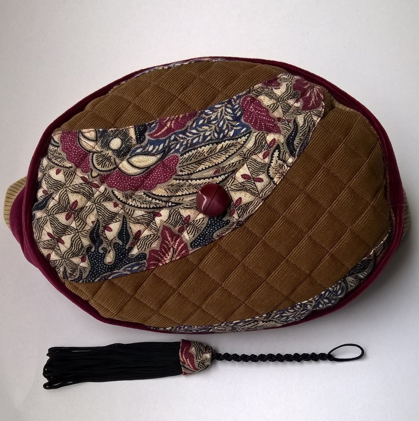 Shows the quilted tip with paisley applique, central vintage button and removable tassel