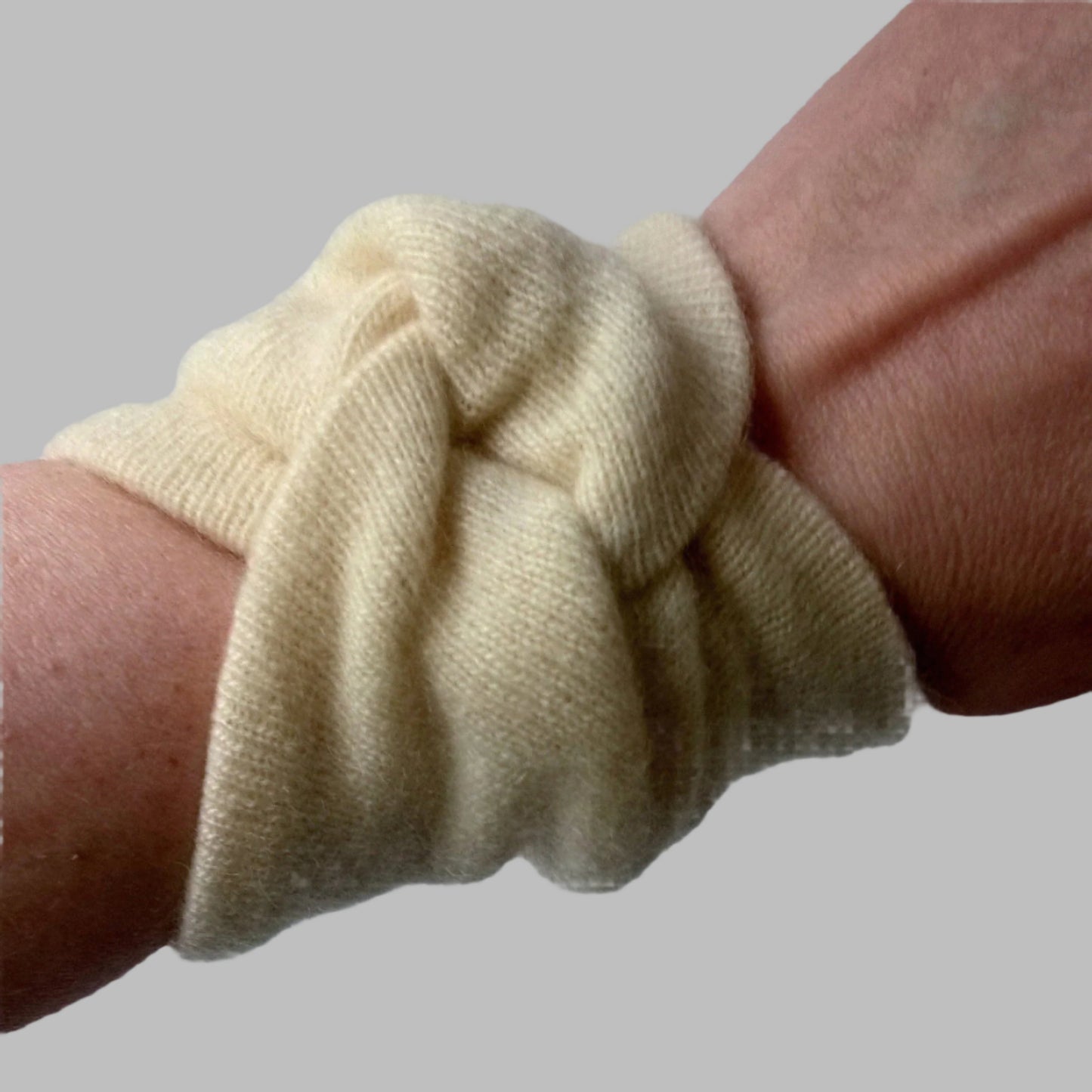 Cream coloured pure cashmere wrist warmers  being worn