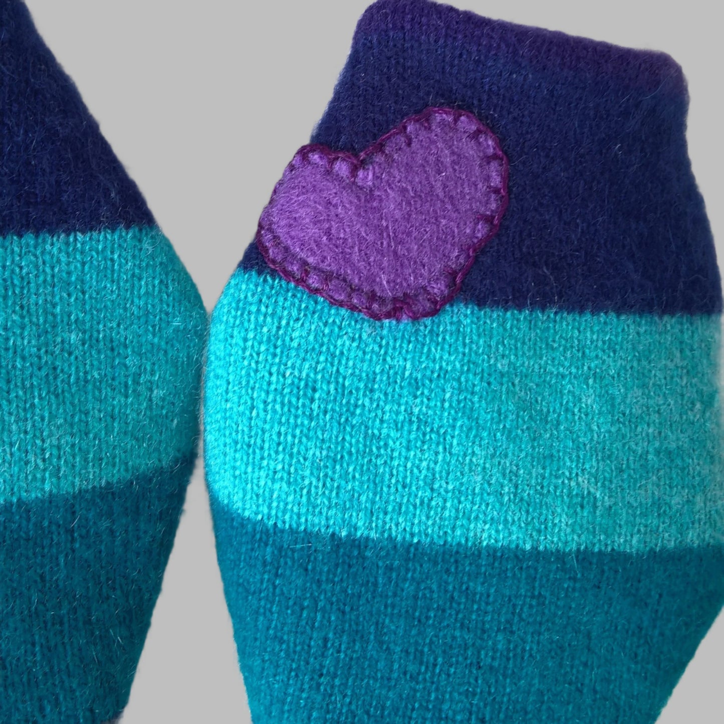 A purple cashmere heart has been appliqued to one wrist cuff