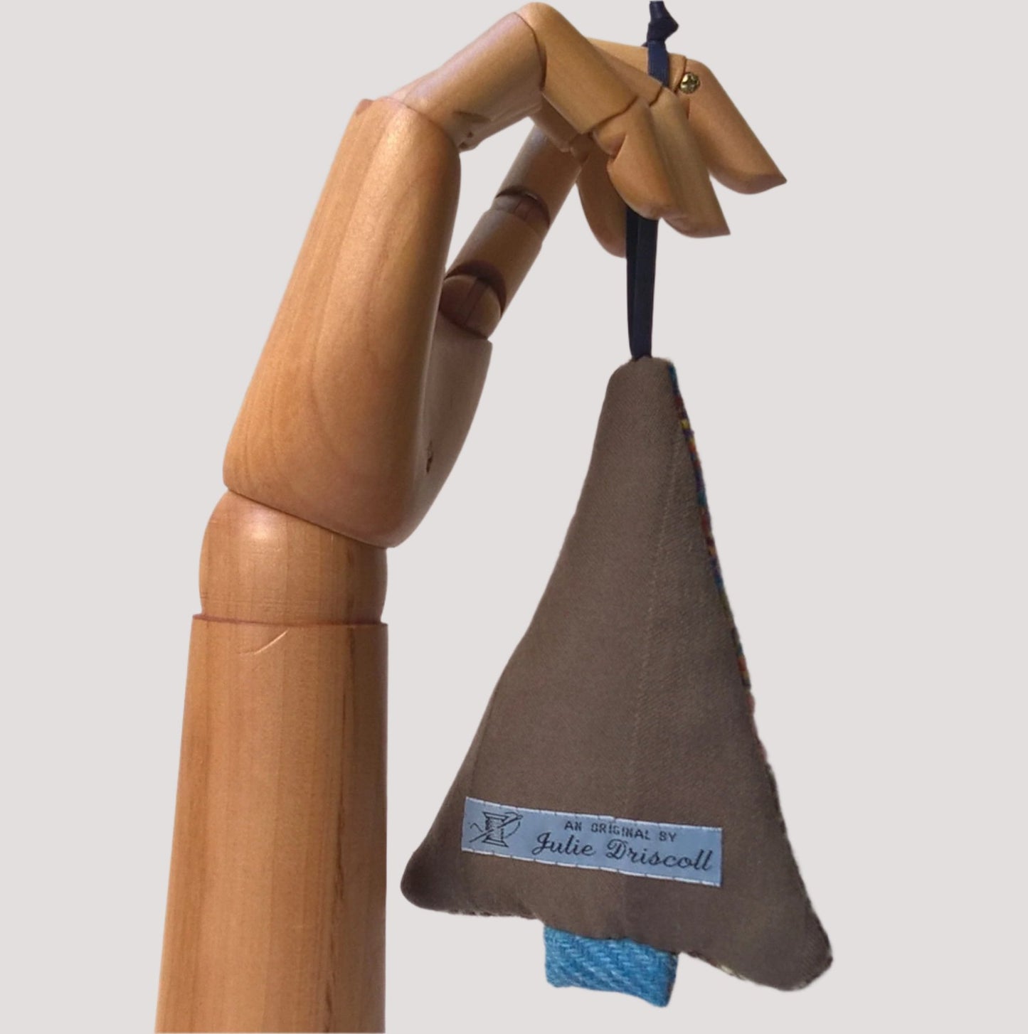 The back of hanging tree ornament is brown 100% wool fabric