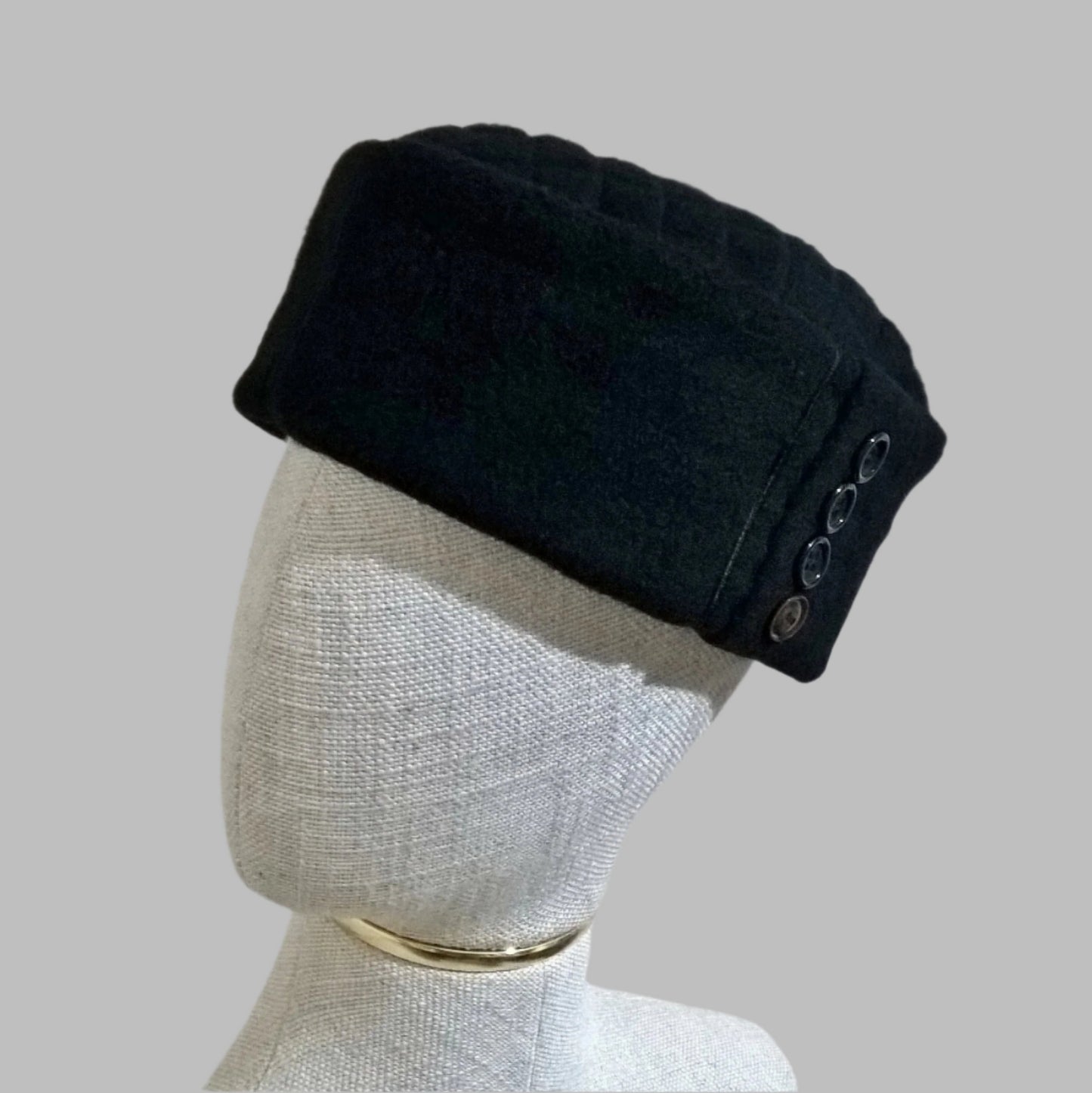 Black cashmere pillbox cap with button detail on crown