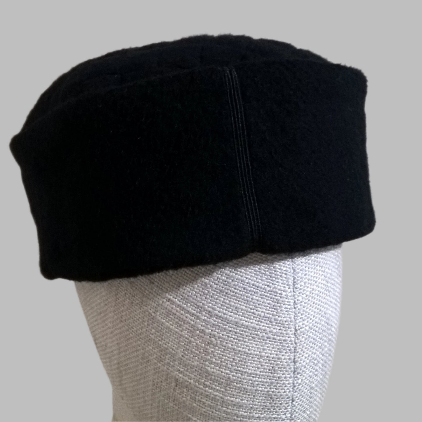 Smart black cashmere skull cap with satin braid and button detail on Crown