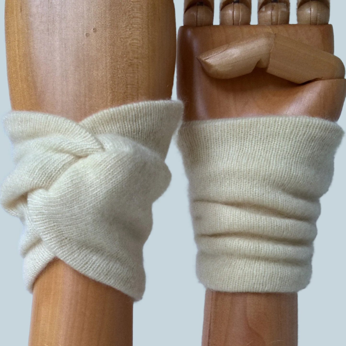 Cream cashmere wrist warmers in a knot design