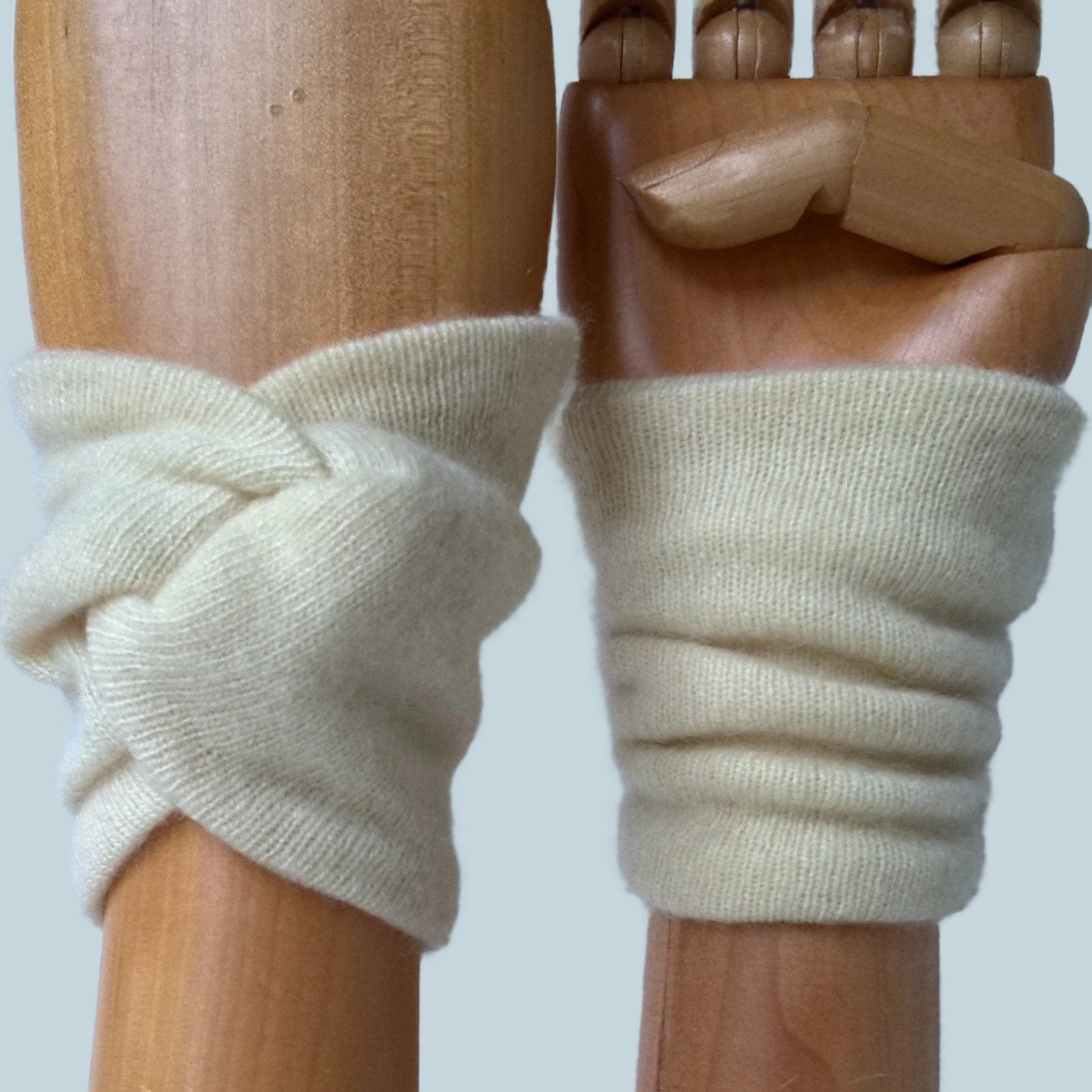 Cream cashmere wrist warmers in a knot design