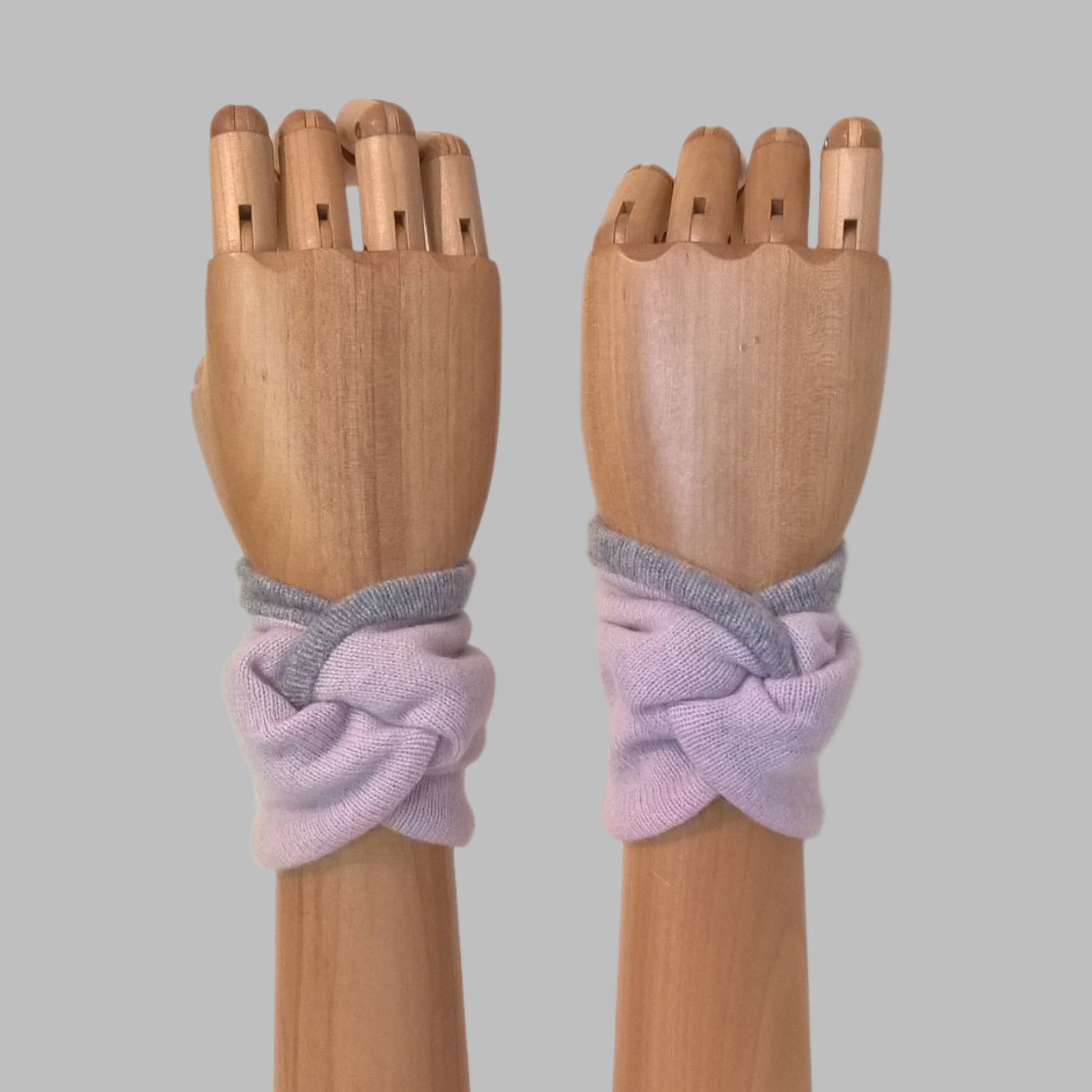 Wrist warmer cuffs handmade in a knot design, soft dusky pink pure cashmere edged and lined with pale grey cashmere