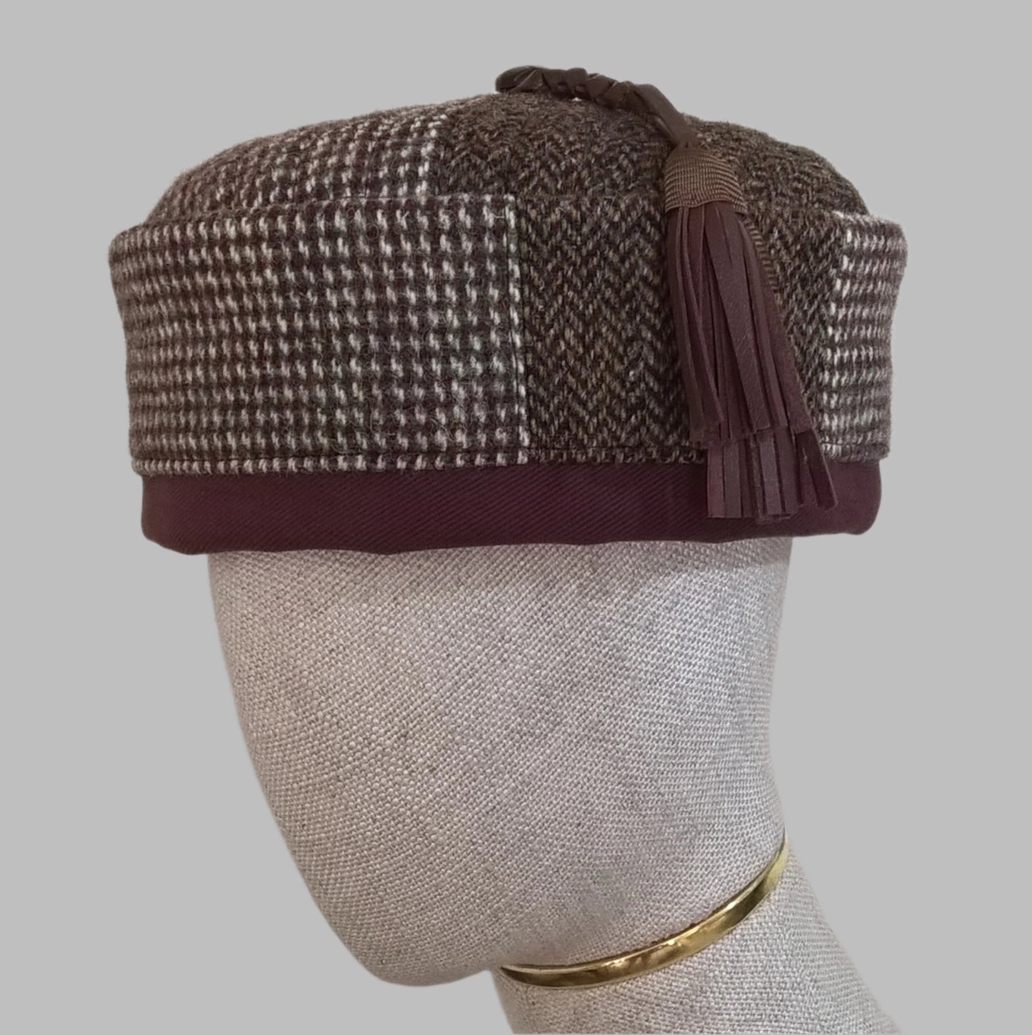 Mismatched patchwork smoking cap from up-cycled Harris tweed jackets finished with a removable leather tassel