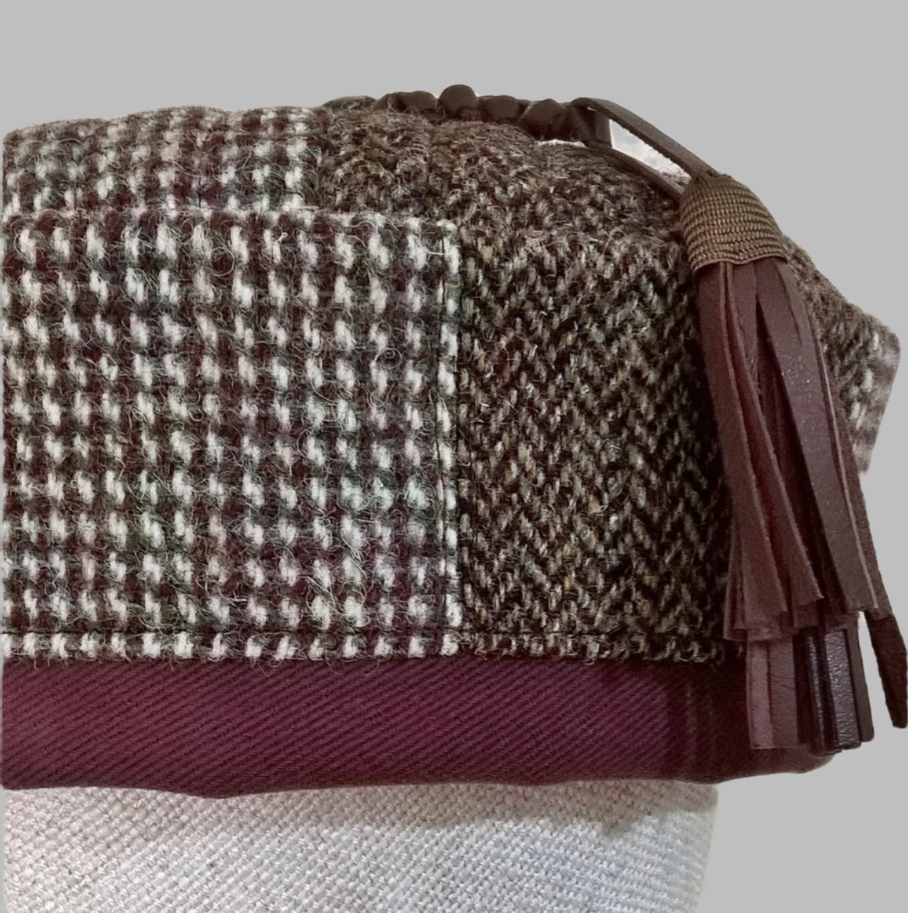 Fabric from two Harris Tweed jackets has been used to make this pillbox shaped patchwork  smoking cap, complimented with maroon edging