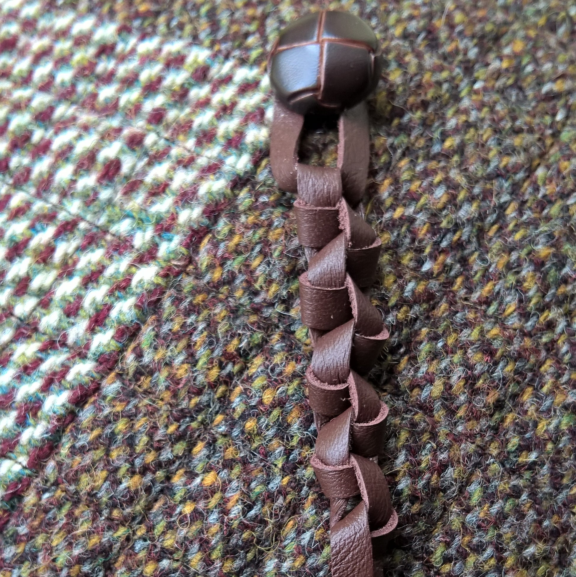 The tip of the hat is finished with a vintage jacket button and removable macrame leather tassel