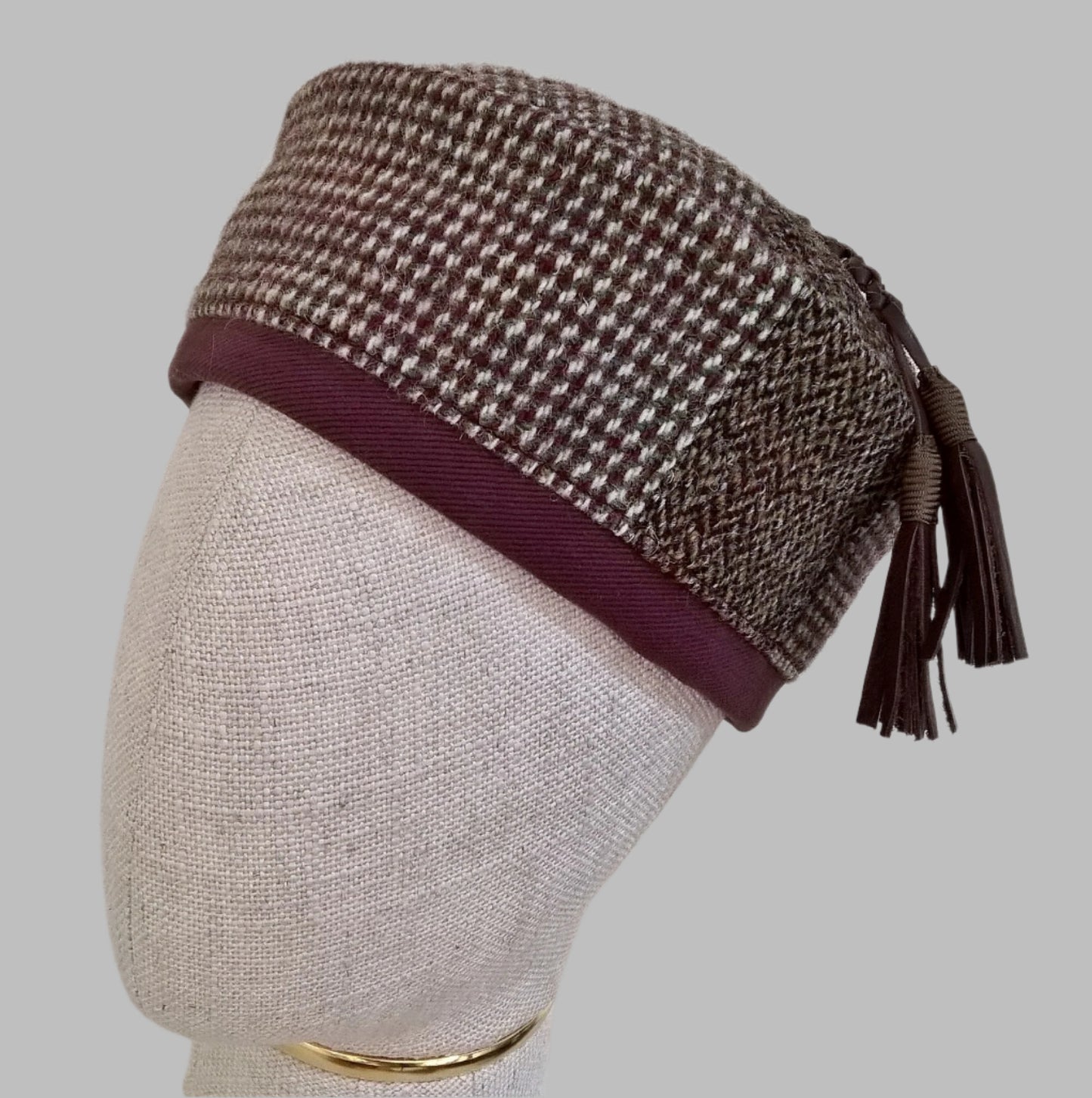 Harris Tweed wool smoking cap, in browns, cream and mauve shades, with leather tassel 