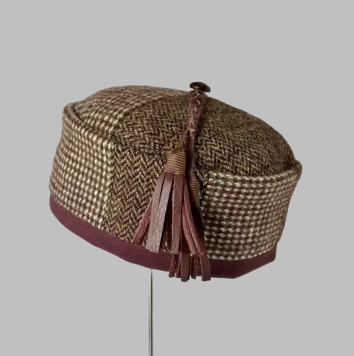 Harris Tweed wool smoking cap, in browns, cream and mauve shades, with leather tassel