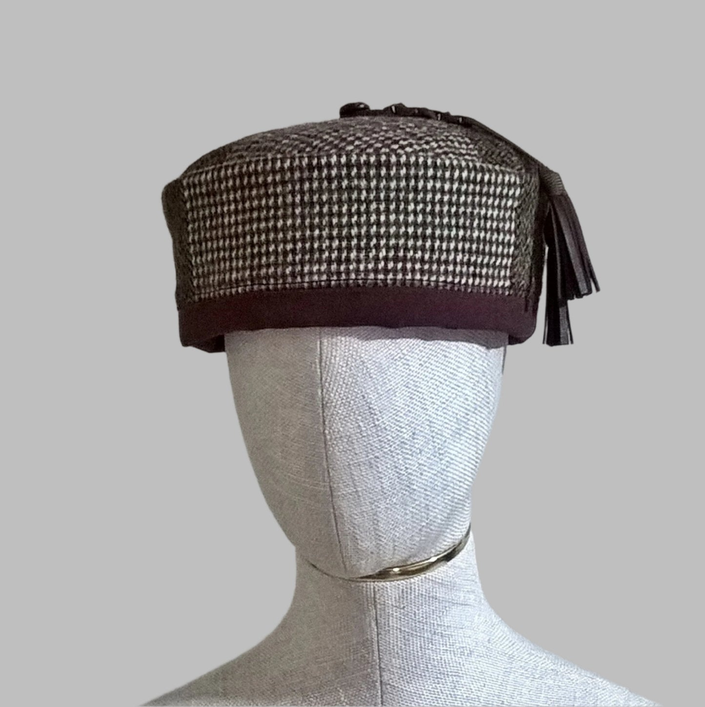 Front view of Harris tweed brimless hat with leather tassel