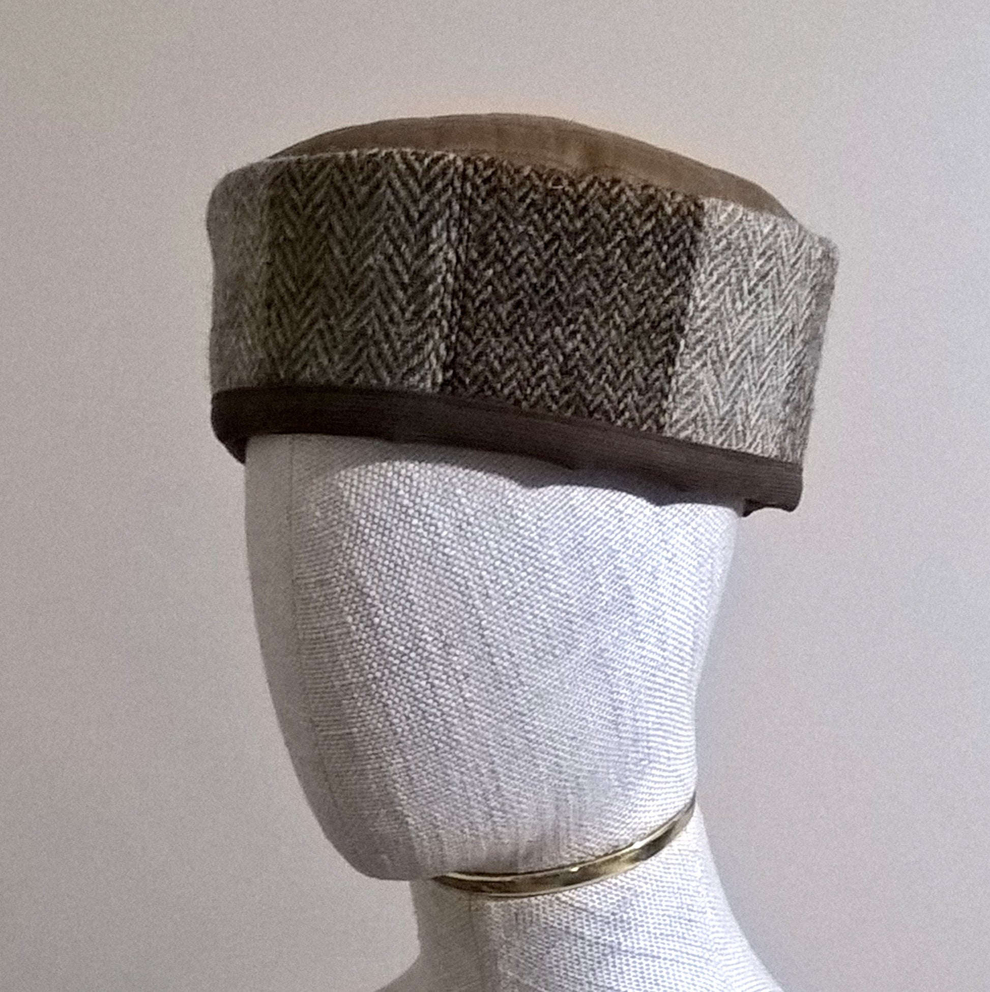 Smoking cap has a Harris Tweed wool patchwork crown edged with dark chocolate brown cotton, and a wool silk mix tobacco coloured quilted tip