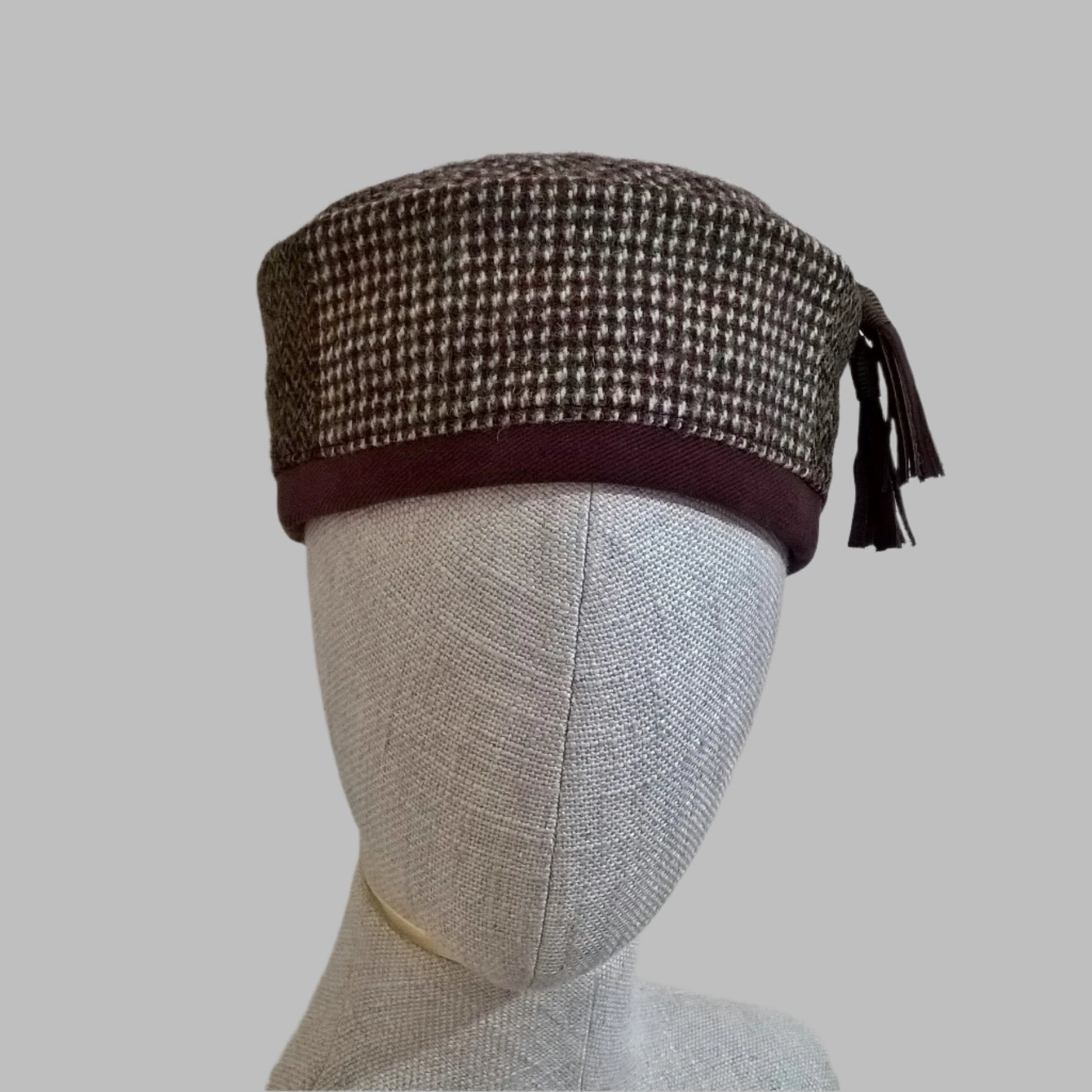 Harris Tweed wool smoking cap, in browns, cream and mauve shades, with macrame leather tassel