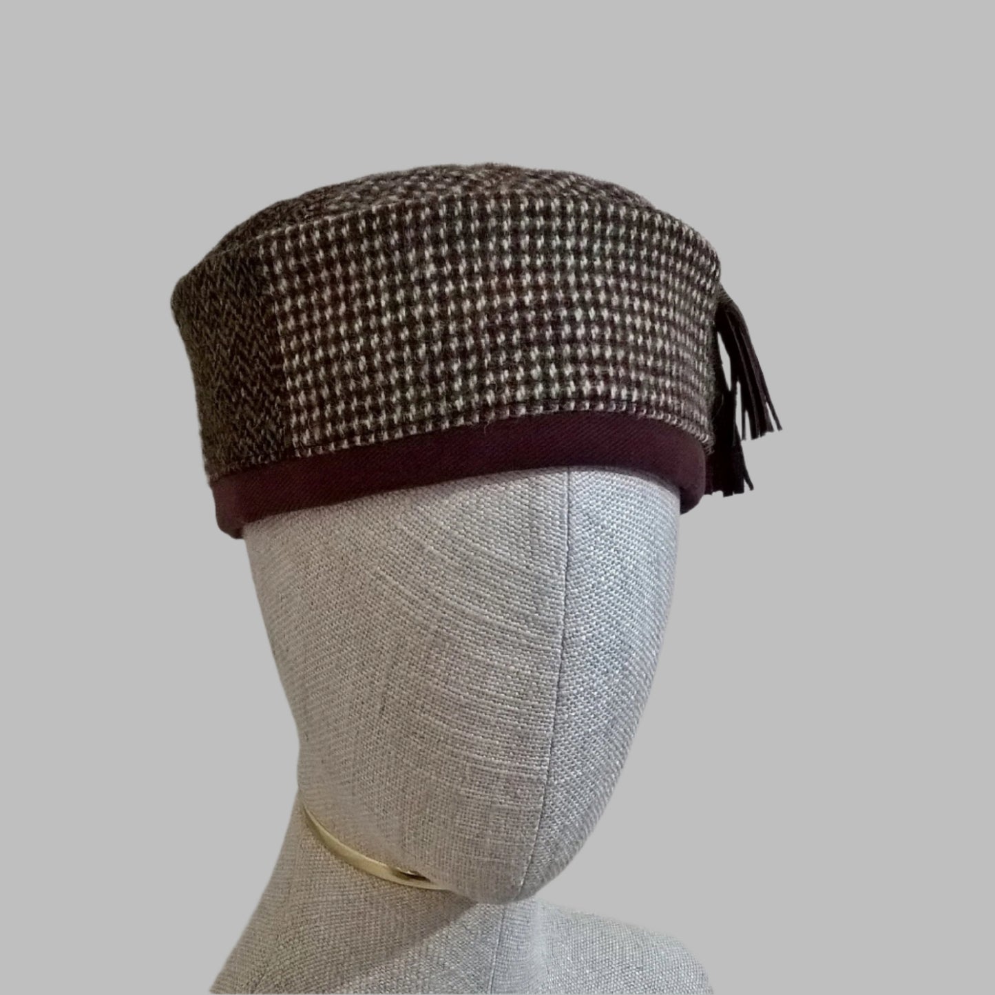 Harris Tweed wool smoking cap, in browns, cream and mauve shades, with leather tassel