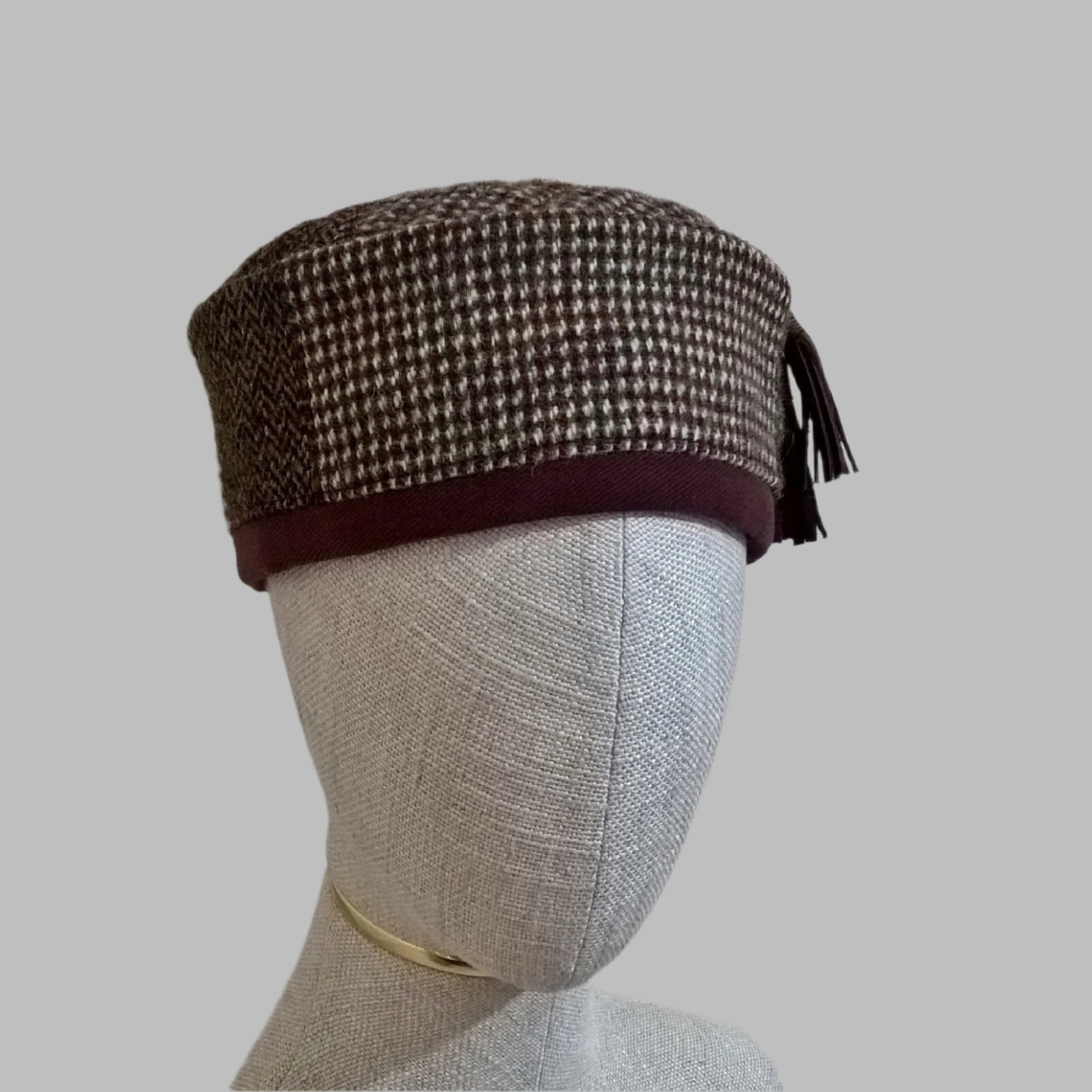 Harris Tweed wool smoking cap, in browns, cream and mauve shades, with leather tassel