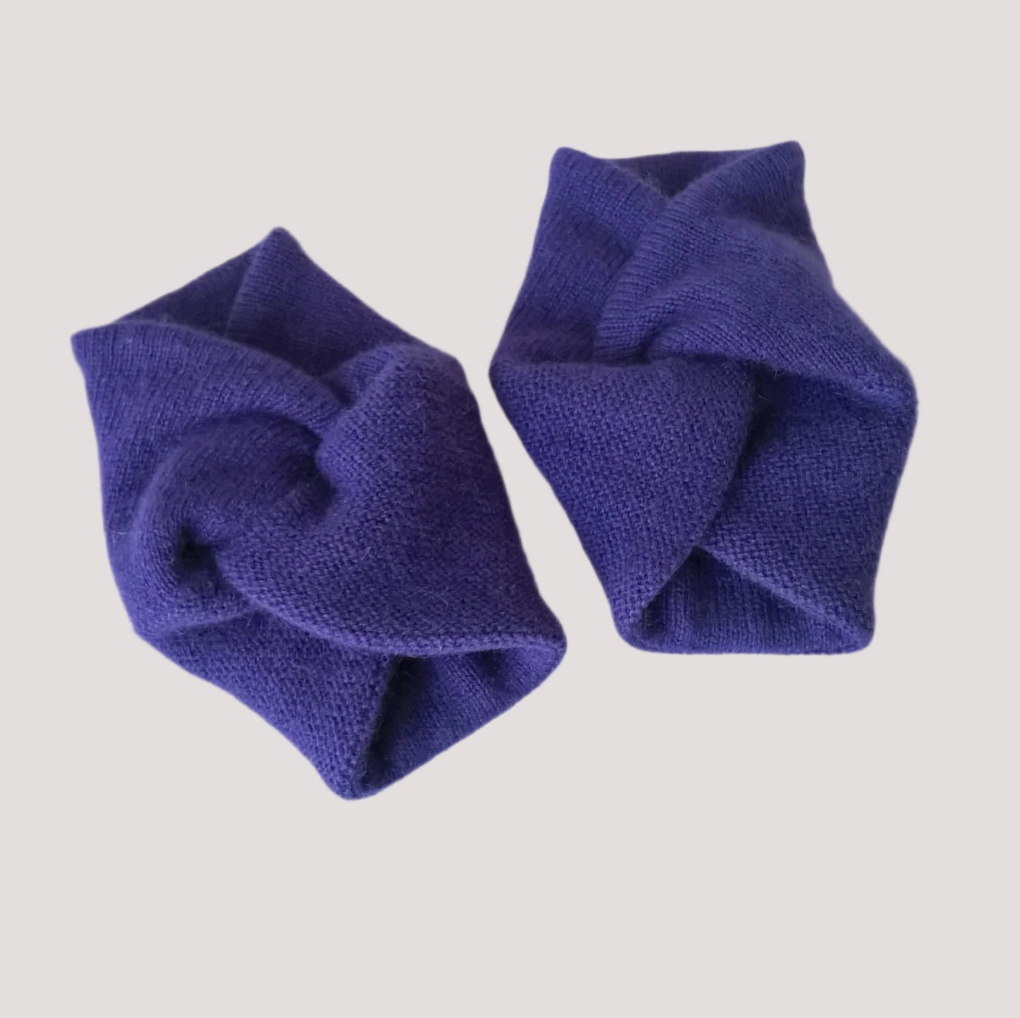 A pair of wrist warmers handmade in a twisted knot design