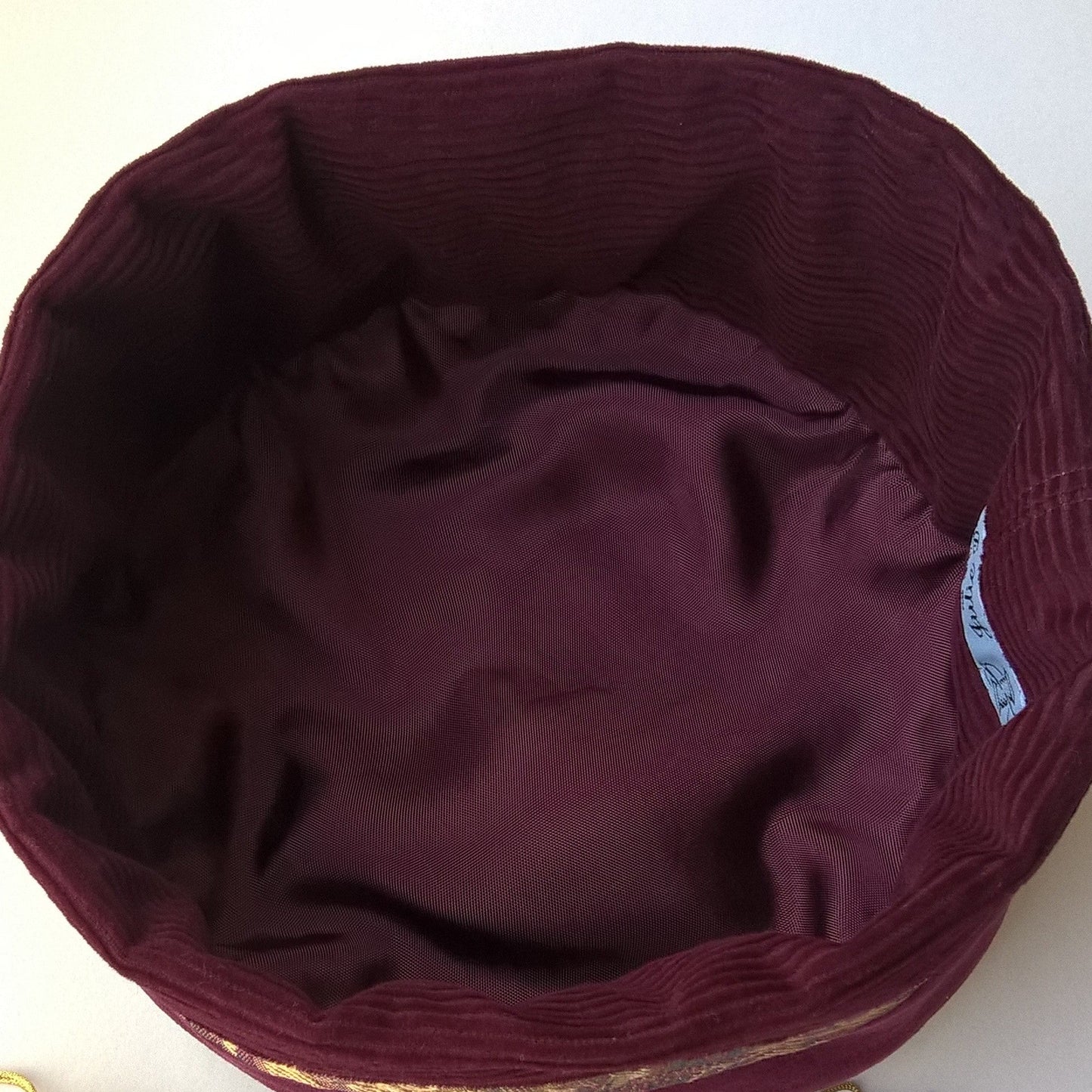 The hat is lined with wine coloured cotton corduroy and rayon