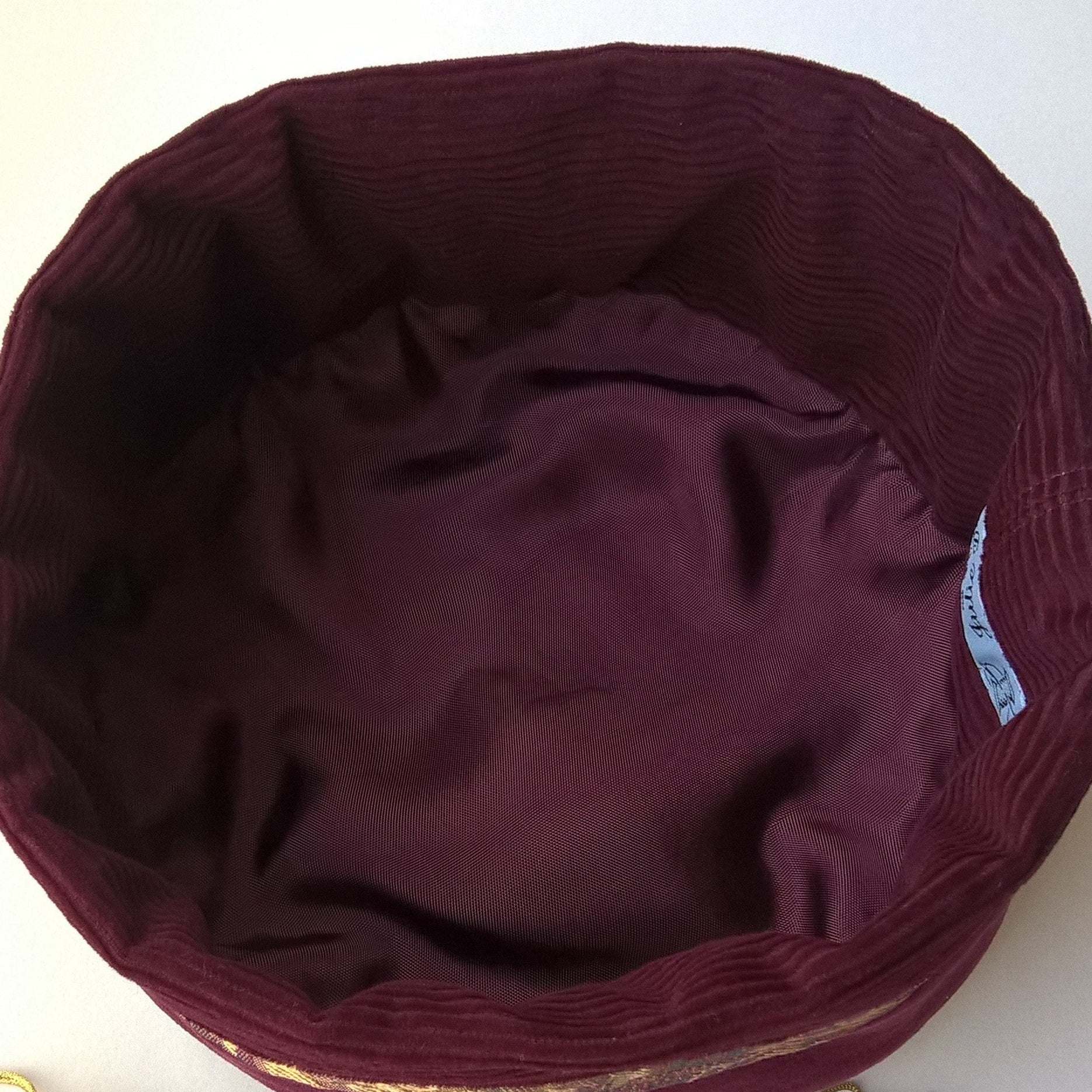 The hat is lined with wine coloured cotton corduroy and rayon