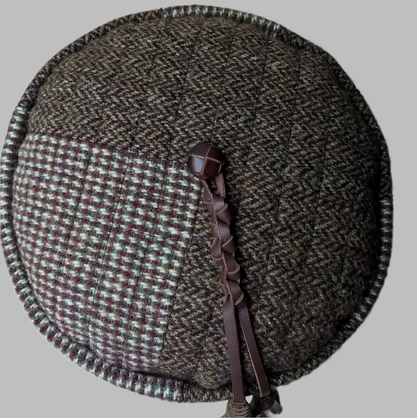 Tip of the Harris Tweed smoking cap with vintsge jacket button and macrame leather tassel