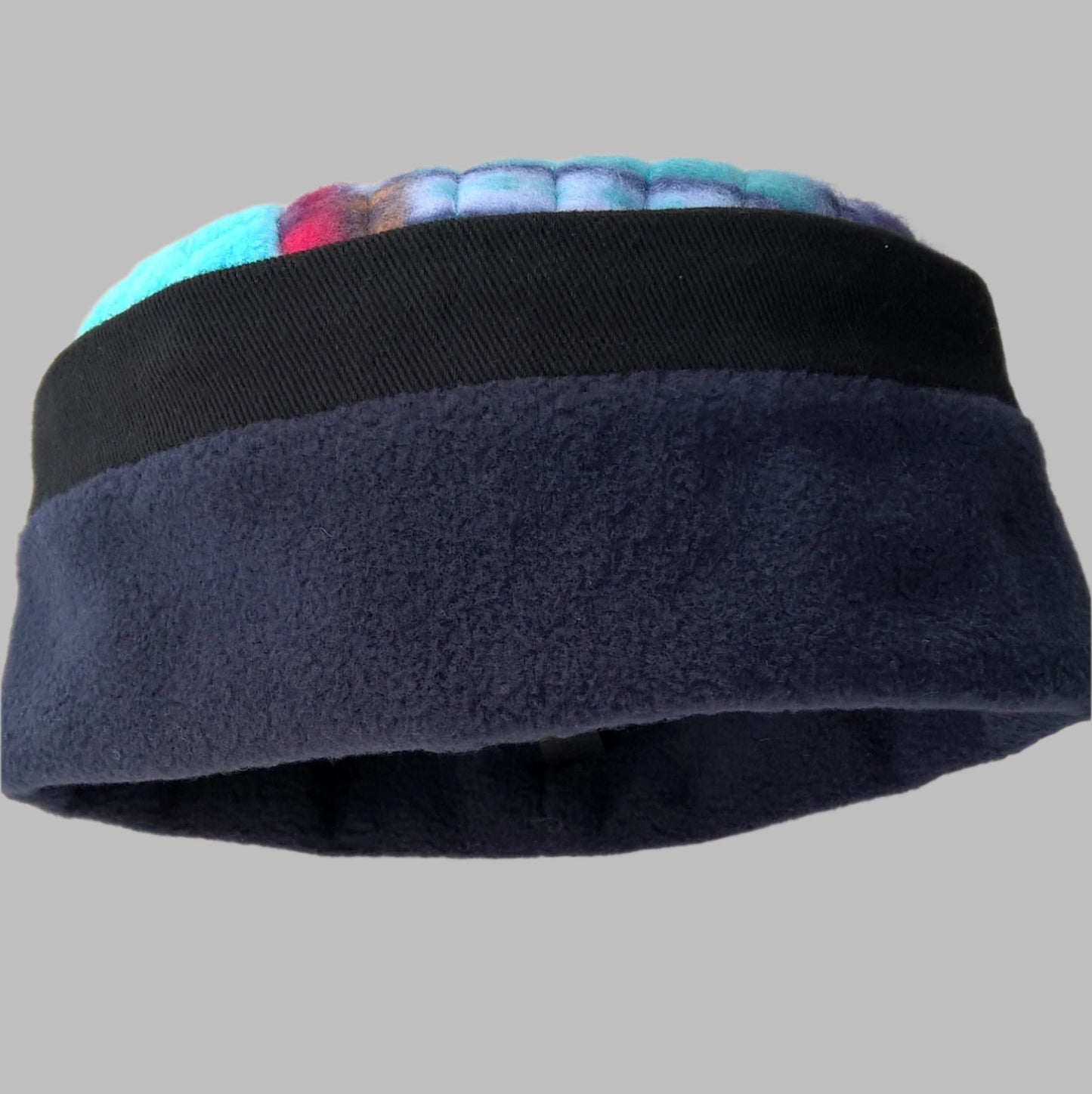 Navy blue fleece hat with black cotton twill edging and multi coloured patchwork tip.