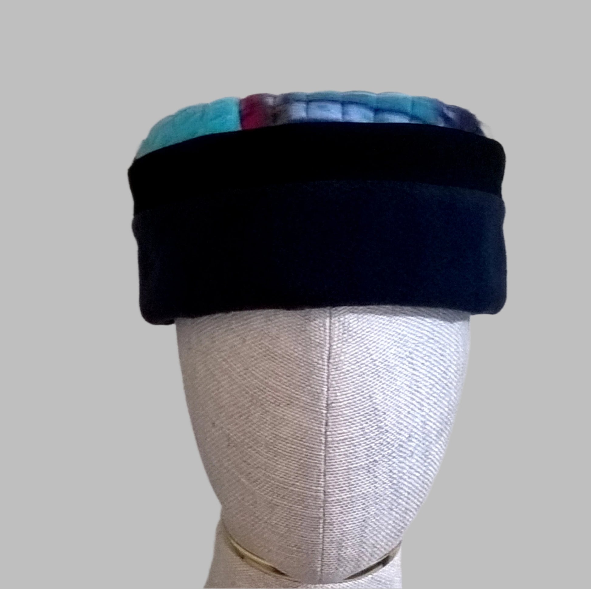 Fleece pillbox cap with a navy crown edged with black and a tribal multi coloured tip
