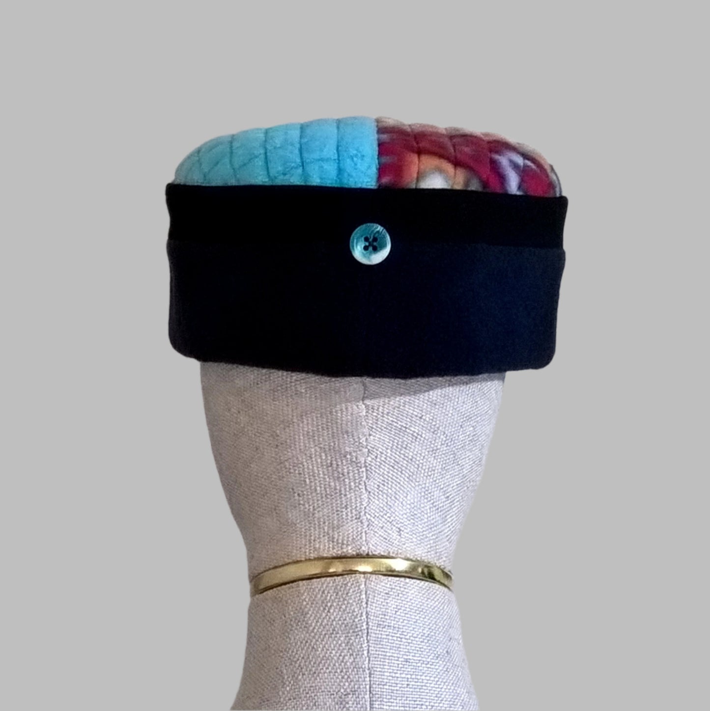Fleece hat has button detail at centre back which echos the turquoise of the tip.