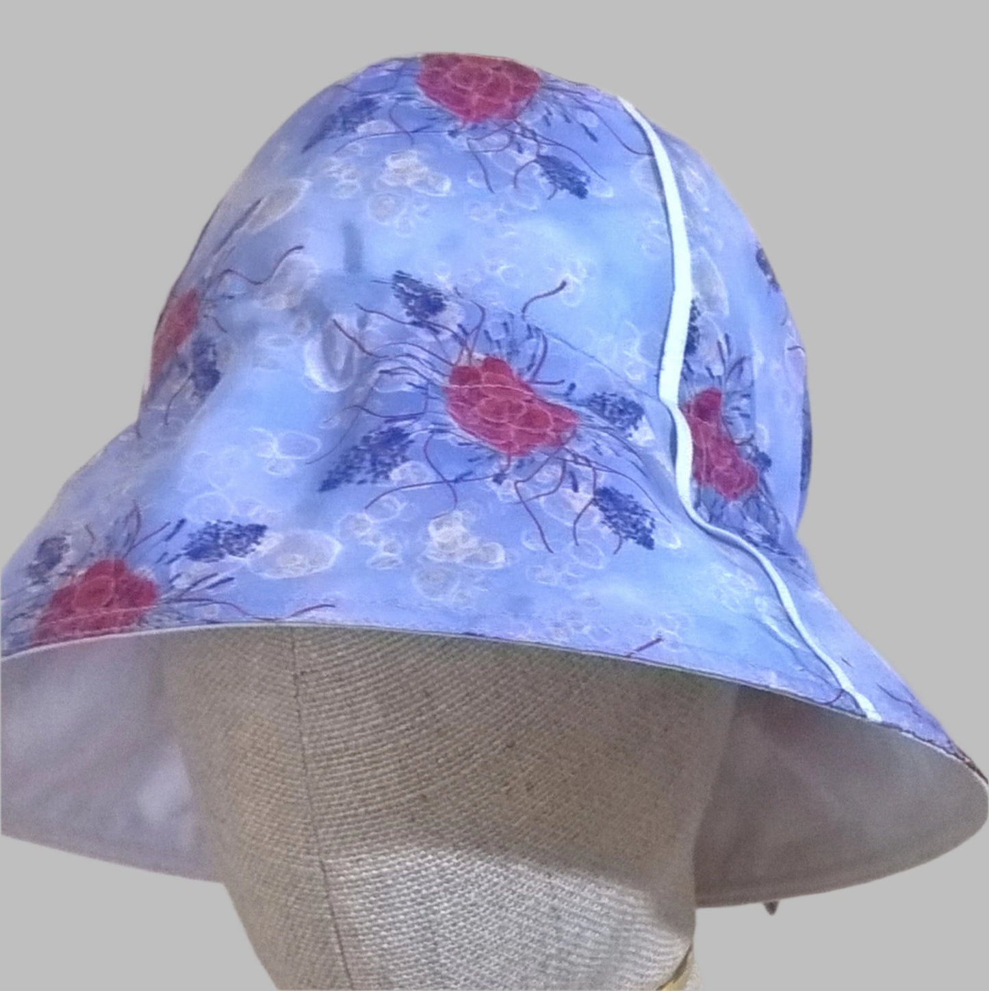 The cotton silk bucket hat has a wired brim and white piping