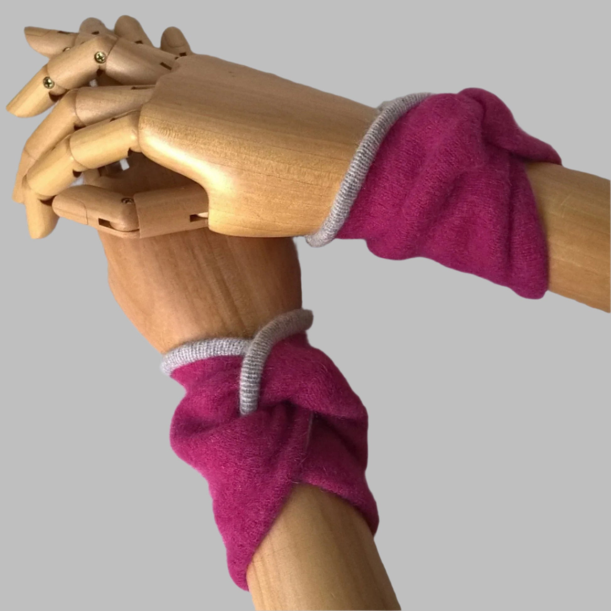 Raspberry pink wrist warmers in a twisted knot design