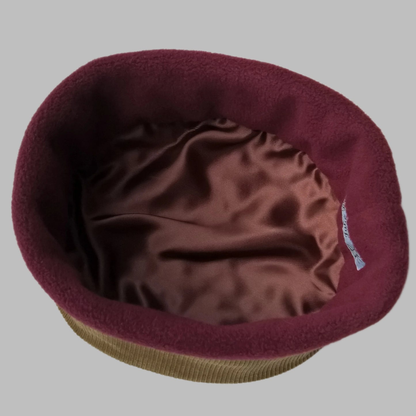 The hat is half lined with burgundy fleece and finished with chocolate brown satin