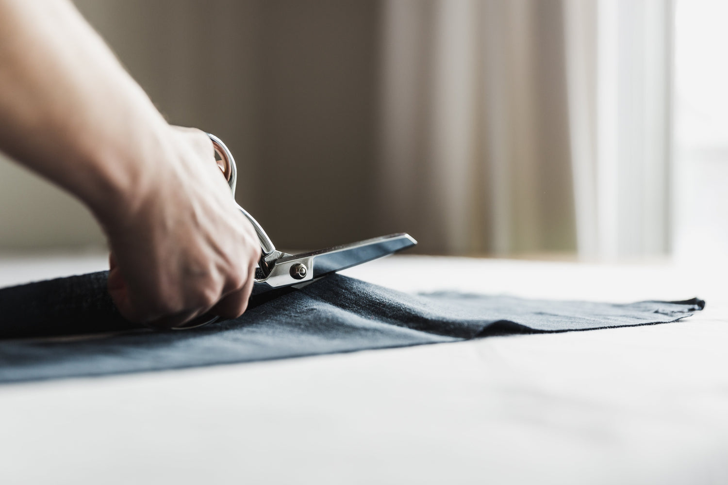 Fabric being hand cut with scissors 