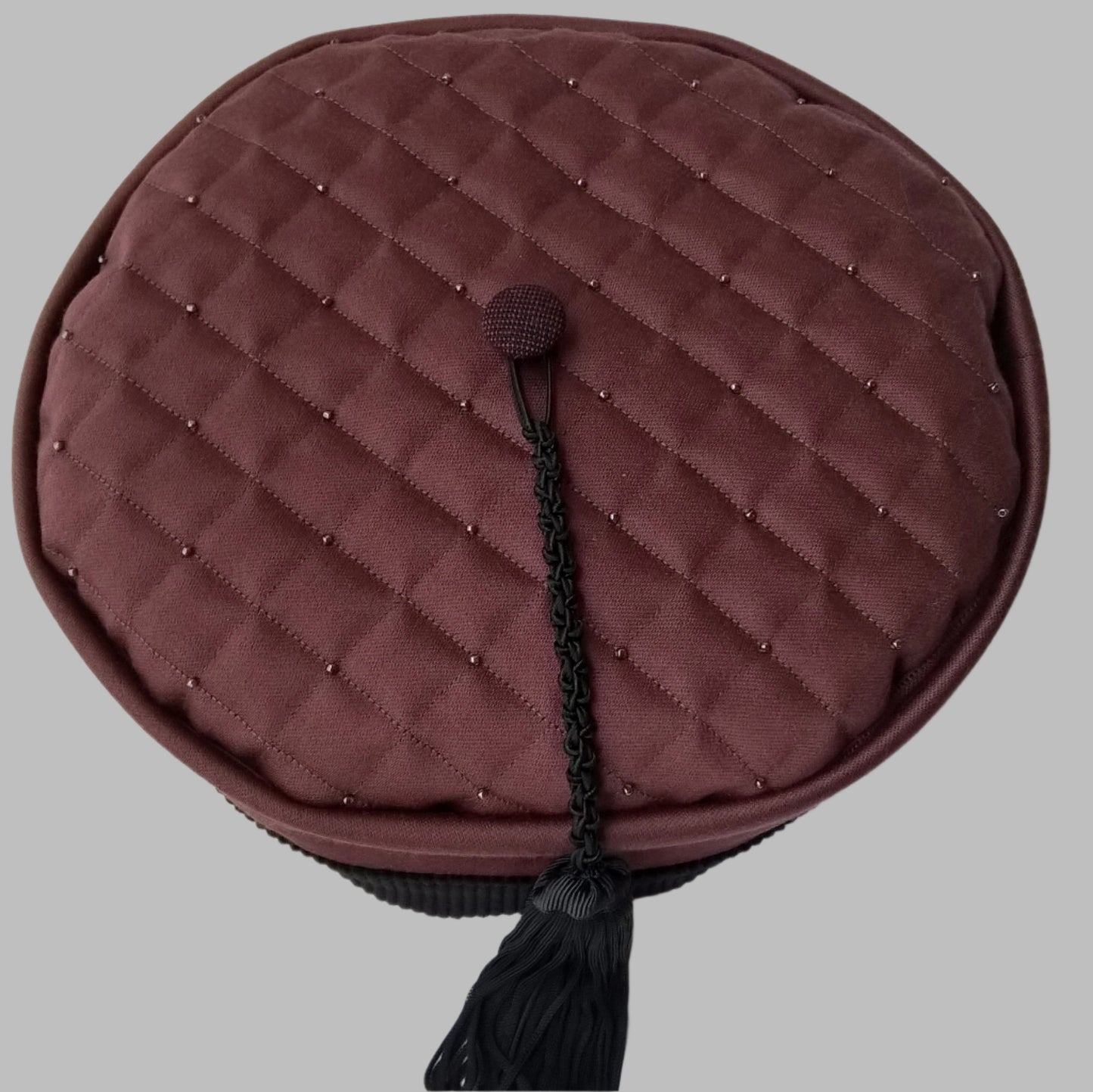 The quilted and beaded tip of the smoking cap