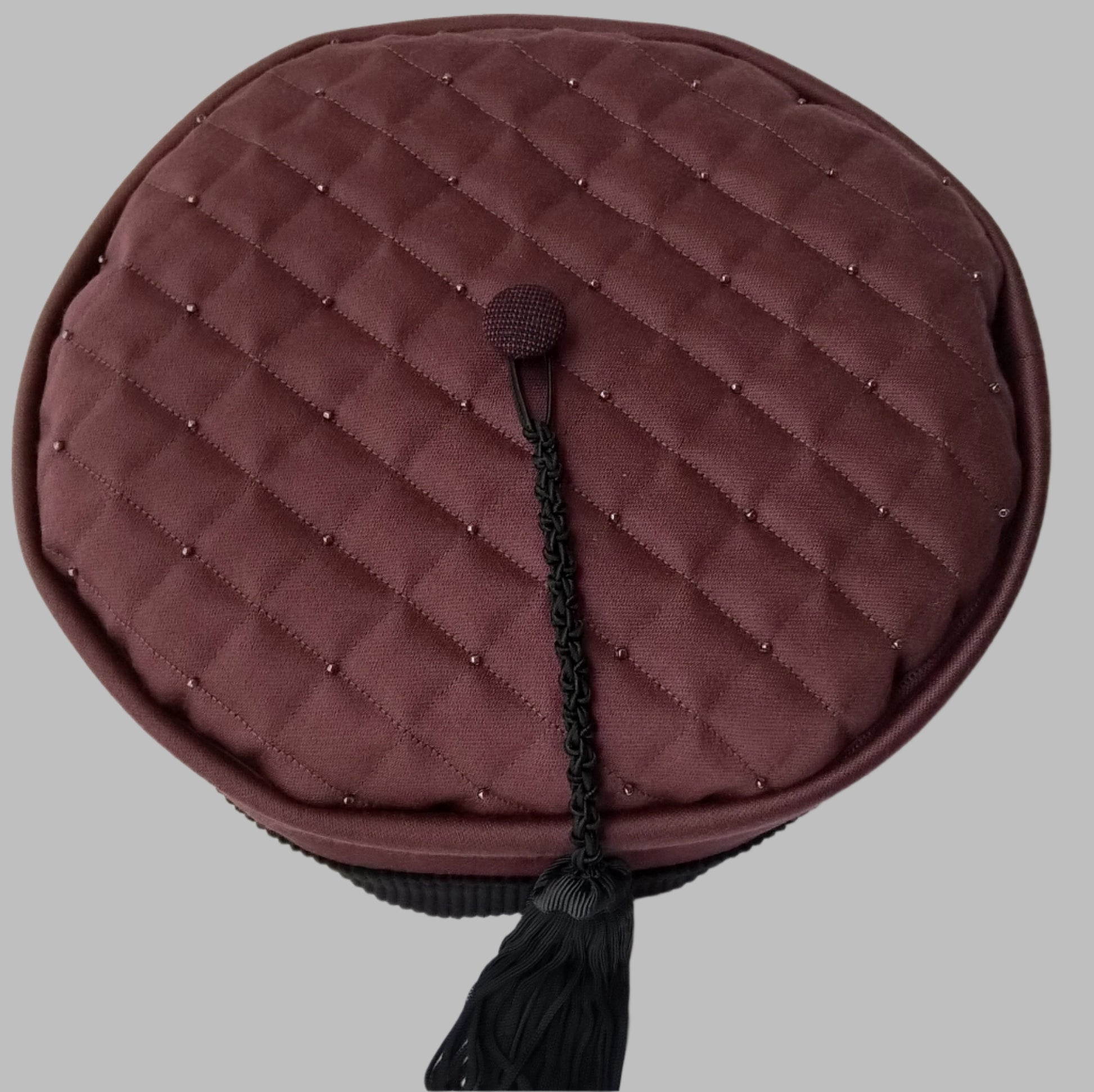The quilted and beaded tip of the smoking cap