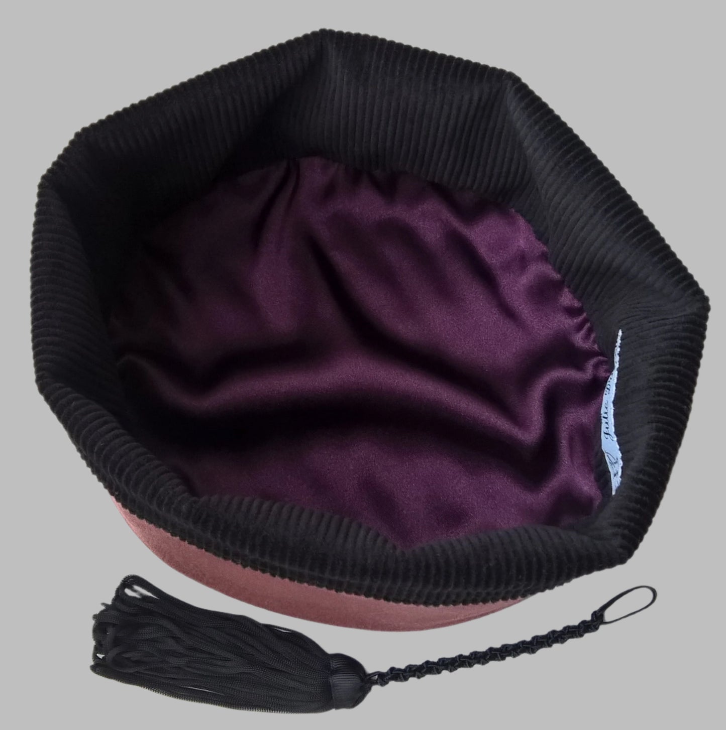 The smoking cap is lined with black cotton corduroy and aubergine satin
