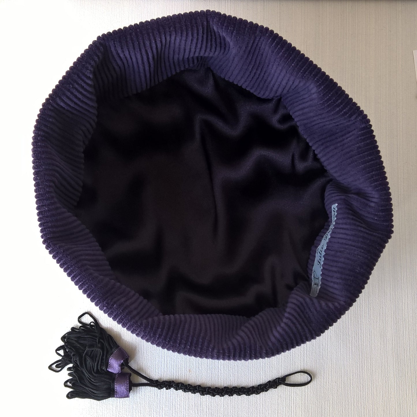 The smoking cap has a satin liining and removable tassel