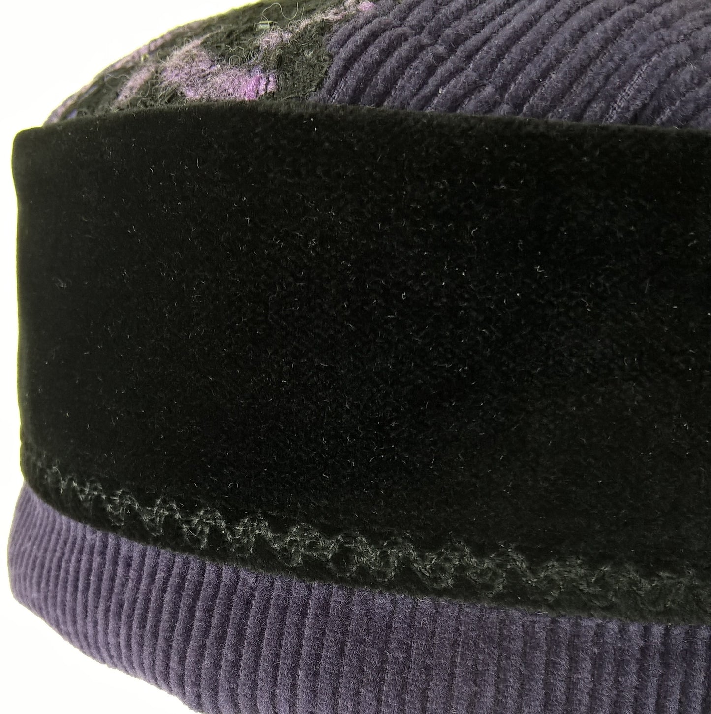 Machine embroidery in a swirl design  embellishes the velvet crown