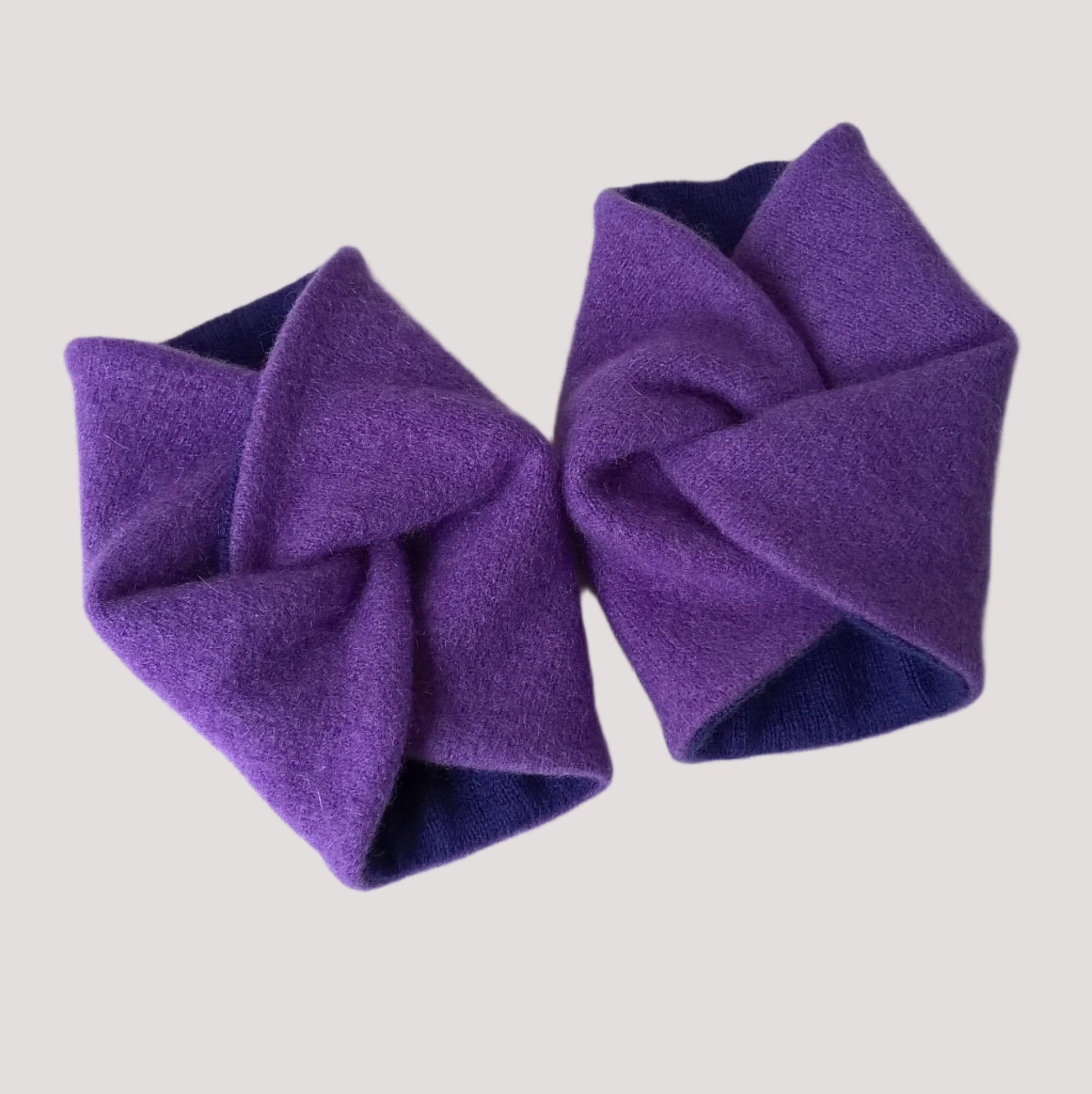 Violet cashmere wrist warmers in a twisted knot design