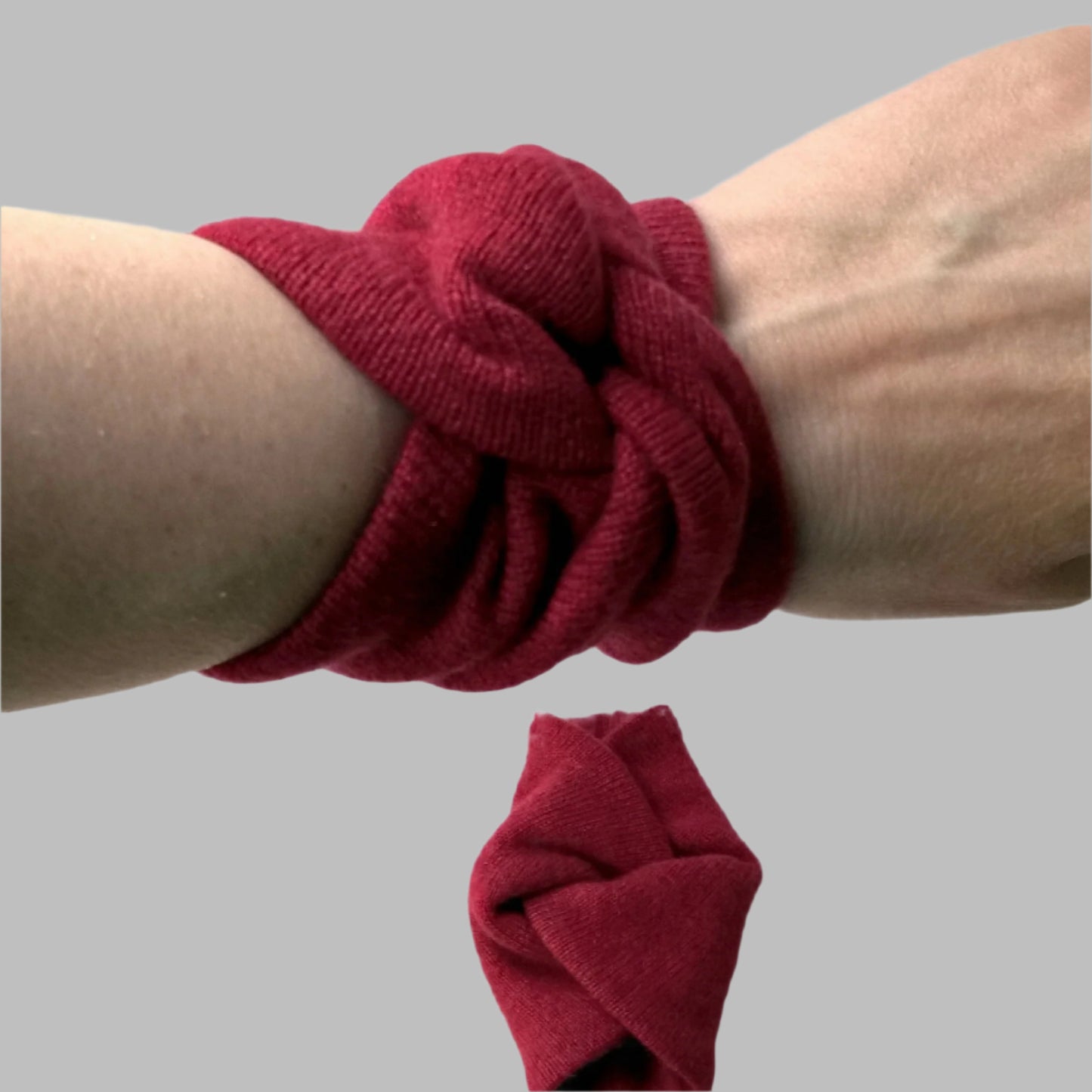 Ruby red pure cashmere wrist warmers in a short wrist knot design